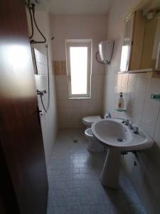 a bathroom with a sink and a toilet and a window at Villa Bianca in Ioppolo