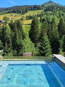 a swimming pool with a view of trees and mountains at Красна Поляна Family Club Resorts in Bukovel
