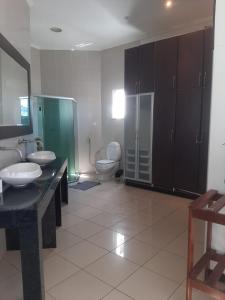 La salle de bains est pourvue de 2 lavabos et de 2 toilettes. dans l'établissement Hostel e Pousada do Bosque, à Rio Branco