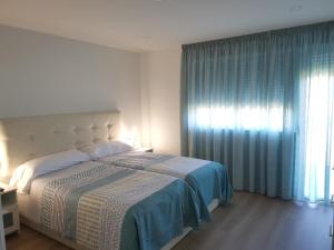 a bedroom with a large bed and a window at Apartamento Gran Terraza in Moaña
