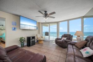 a living room with a couch and a flat screen tv at Shores Club 703 in Daytona Beach