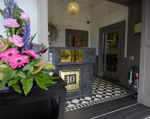 uma lareira num corredor com flores sobre uma mesa em Number 10 Hotel em Glasgow