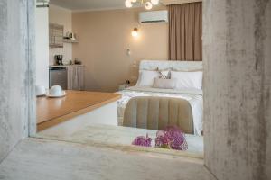 1 dormitorio con 1 cama y cocina con mesa en Oniro PargaTown Luxury Suites, en Parga