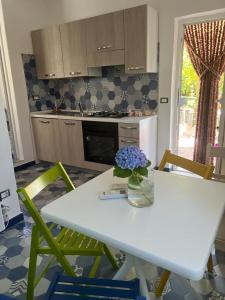 a kitchen with a white table and green chairs at Casa Buono in Ischia
