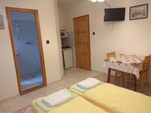 a room with a table and a glass shower at Lívia Apartman in Balatonfüred
