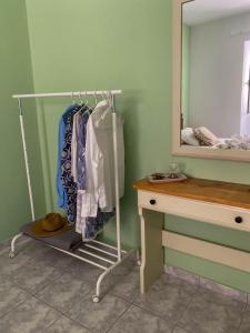 a dressing room with a rack of clothes and a mirror at Ares Apartment, Town of Poros Island in Poros