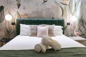 a bedroom with a large white bed with a green headboard at Ammare rooms in Agrigento
