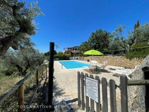 a swimming pool with a sign next to a fence at Casa Sophia con piscina - ingresso, giardino, barbecue e parcheggio privati by ToscanaTour in Guardistallo