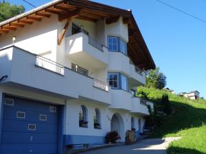 卡普爾的住宿－Haus Siegele Marco，白色的房子,设有蓝色车库