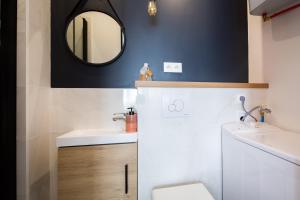 uma casa de banho com um lavatório e um espelho em Les Studios du Parc Bordelais - Le Canelé em Le Bouscat