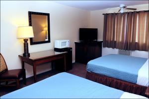 Pokój hotelowy z 2 łóżkami i biurkiem z telewizorem w obiekcie Antler Motel w mieście Kemmerer
