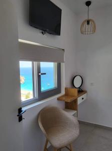 uma cadeira sentada num quarto com uma janela em Agnantema luxury suites em Cárpatos