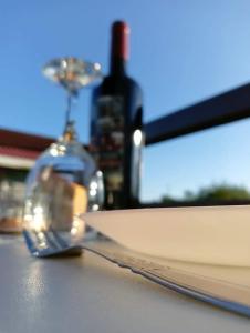 uma garrafa de vinho e um livro sobre uma mesa em Reinhardshausen Suites and Residences - Cozy Air-conditioned Units em Tuguegarão