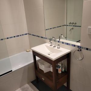 La salle de bains blanche est pourvue d'un lavabo et d'une baignoire. dans l'établissement Ibera apartment, à Buenos Aires