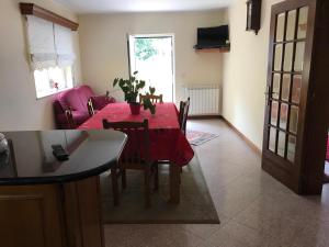 a dining room with a red table and chairs and a room at Moradia Com Piscina T4 in Esposende