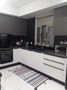 a kitchen with black and white counters and appliances at Near the airport Kiriaki's House in Heraklio