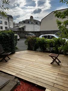 a wooden deck with two benches on top of it at Charmant studio au calme terrasse privée place de parking sécurisée in Angers