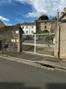 a white fence on the side of a street at Charmant studio au calme terrasse privée place de parking sécurisée in Angers