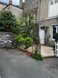 a house with a fence next to a building at Charmant studio au calme terrasse privée place de parking sécurisée in Angers