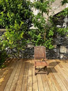a wooden chair sitting on a wooden deck at Charmant studio au calme terrasse privée place de parking sécurisée in Angers