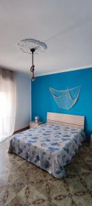1 dormitorio con 1 cama con pared azul en Azzurro come il Mare en Termoli