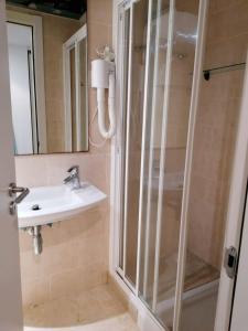 bagno con doccia, lavandino e specchio di Apartamento Cala Busquets a Ciutadella