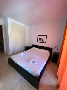 una camera da letto con un grande letto con due cuscini sopra di Apartamento Cala Busquets a Ciutadella