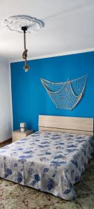 a blue bedroom with a bed and a hammock on the wall at Azzurro come il Mare in Termoli