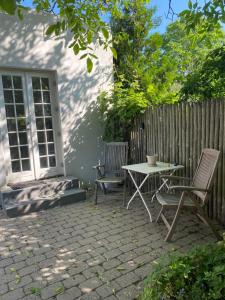 a patio with two chairs and a table and a fence at Annex near beach close to Copenhagen in Vedbæk