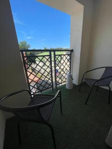 a room with two chairs and a balcony with a view at Apartamenty i Pokoje Atlantic in Jastrzębia Góra