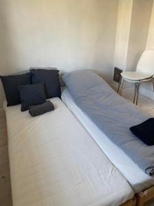 ein Bett mit zwei Kissen auf einem Zimmer in der Unterkunft Annex near beach close to Copenhagen in Vedbæk