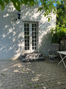 un edificio blanco con una puerta y una silla en Annex near beach close to Copenhagen en Vedbæk