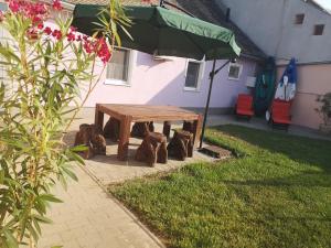 einen Picknicktisch im Garten mit Sonnenschirm in der Unterkunft Levendula Apartman in Makó