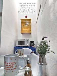 una mesa con dos tazas y un jarrón en ella en Original y Cómodo Loft en el Centro de Tulancingo, en Tulancingo