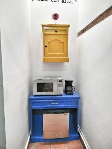 una mesa azul con microondas y un armario amarillo en Original y Cómodo Loft en el Centro de Tulancingo, en Tulancingo