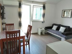 a living room with a couch and a table at Villa Luce Apartment House in Karlobag