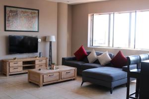 a living room with a couch and a tv at 1007-Stunning Studio apt with incredible Joburg views in Johannesburg +9 photos