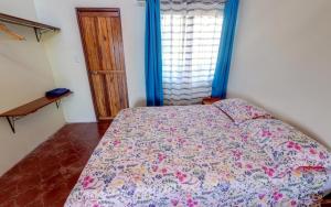a bedroom with a bed with a floral bedspread at Vista Lago Arenal in Piedras