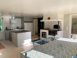 una cocina con armarios blancos y una mesa con sillas. en Holiday home Tussered Hacksvik en Håcksvik