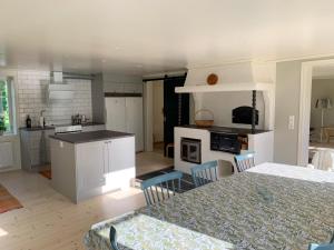 a kitchen with white cabinets and a table with chairs at Holiday home Tussered Hacksvik in Håcksvik