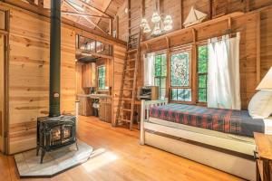 een slaapkamer met een houtkachel in een blokhut bij Deer Creek Cabin in Holland