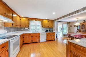 a kitchen with wooden cabinets and white appliances at Cape Charmer in Yarmouth Port