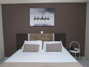 ein Bett mit weißen Laken und Kissen in einem Schlafzimmer in der Unterkunft Marsallis Praia - Flat 404 - Vista Mar in Natal + 31 Fotos