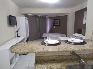 eine Küche mit einem Tisch mit Tellern und Gläsern darauf in der Unterkunft Marsallis Praia - Flat 404 - Vista Mar in Natal