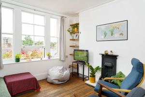 a living room with a blue chair and a television at 50 meters to the metro in London