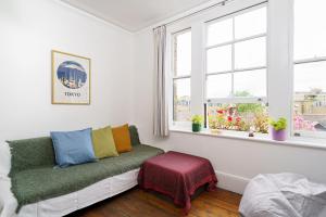 a living room with a couch and two windows at 50 meters to the metro in London