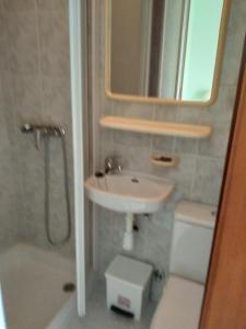 LadridoにあるPension Bajamarのバスルーム(洗面台、トイレ、鏡付)