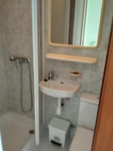 a bathroom with a sink and a toilet and a mirror at Pension Bajamar in Ladrido