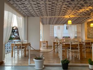 a dining room with tables and chairs and a coffered ceiling at Hotel Fron in Sarandë