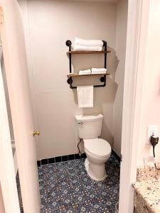 a bathroom with a toilet and towels in it at Dunes Motel Hillsboro in Hillsboro